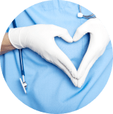 Healthcare professional forming a heart shape with hands over a blue surgical gown.