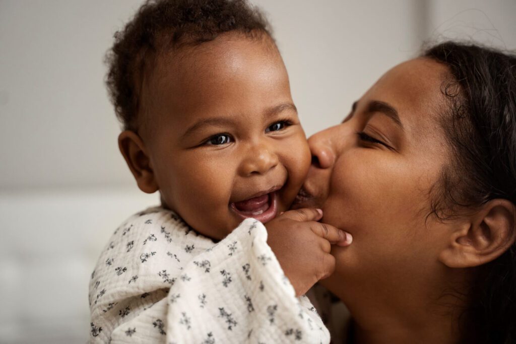 A mother kissing her child on the cheek