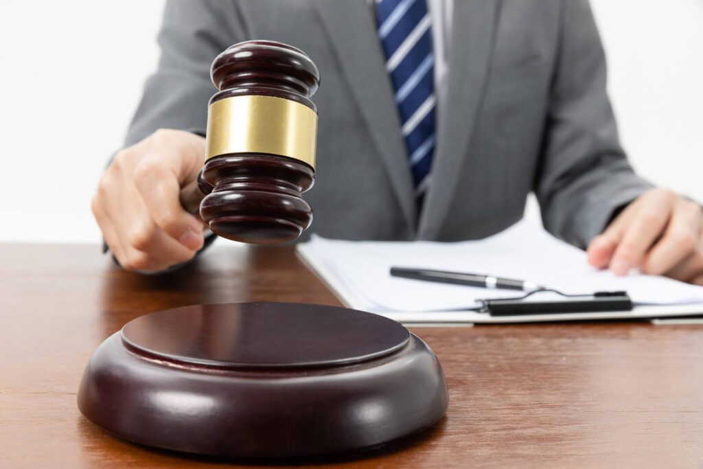 A person holding a gavel and some documents